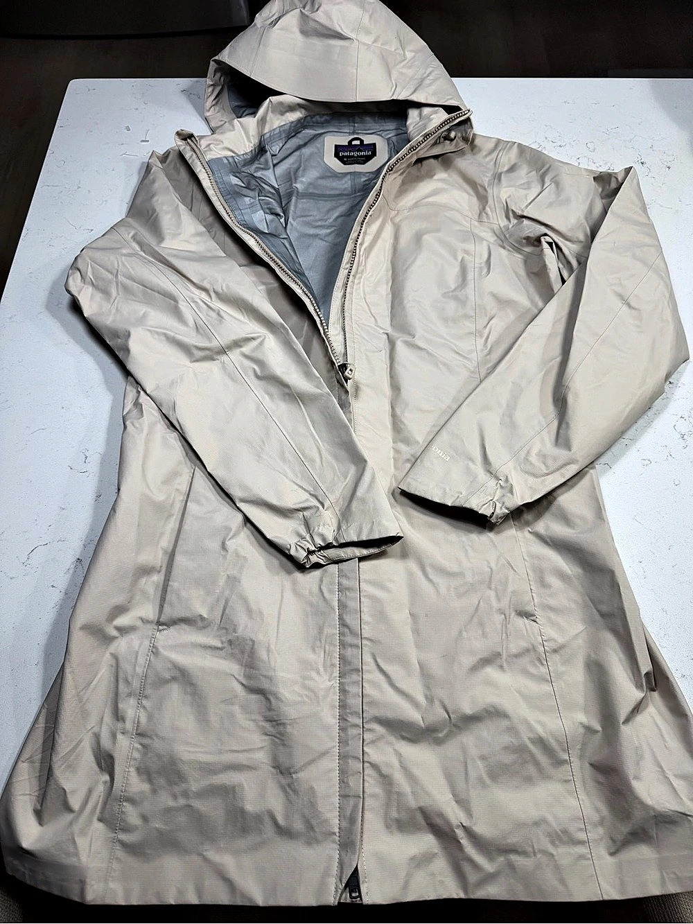 Patagonia women’s long hooded rain jacket/coat in size Medium. Light beige/cream
